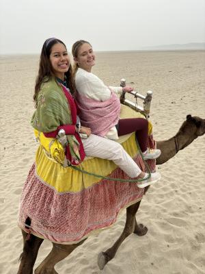 我的队友，旅行伙伴和最好的朋友，凯莉，和我骑着骆驼在另一边...