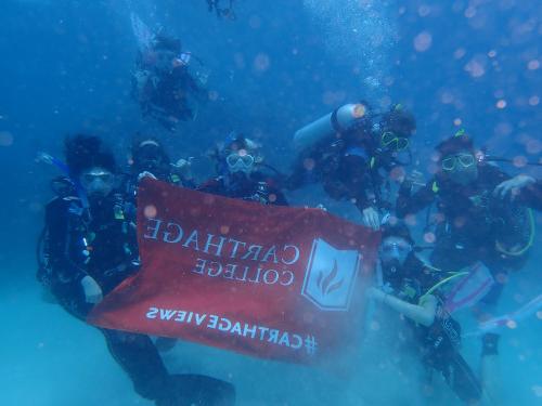 我和我的潜水团队在全球十大赌钱排行app旗帜下拍了一张水下照片.